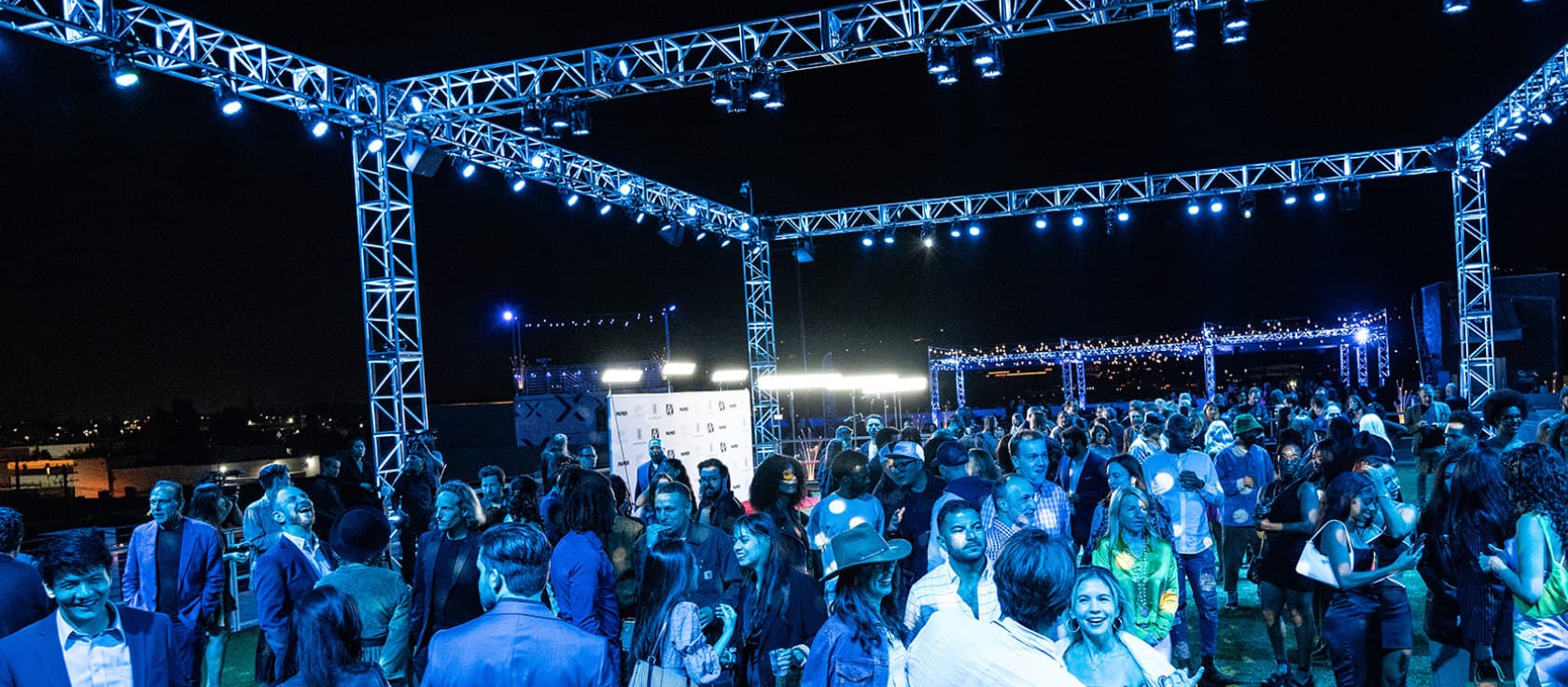 Large outdoor corporate event under a truss lighting system