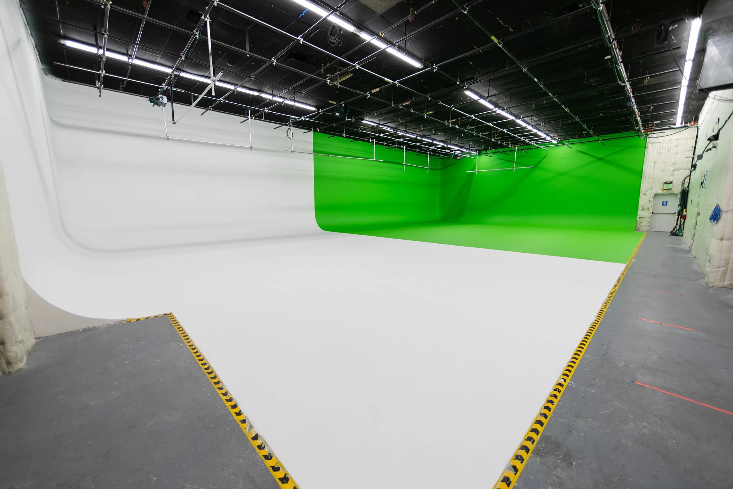 Renovated Burbank production stage with a continuous white floor, chroma wall, and overhead grid