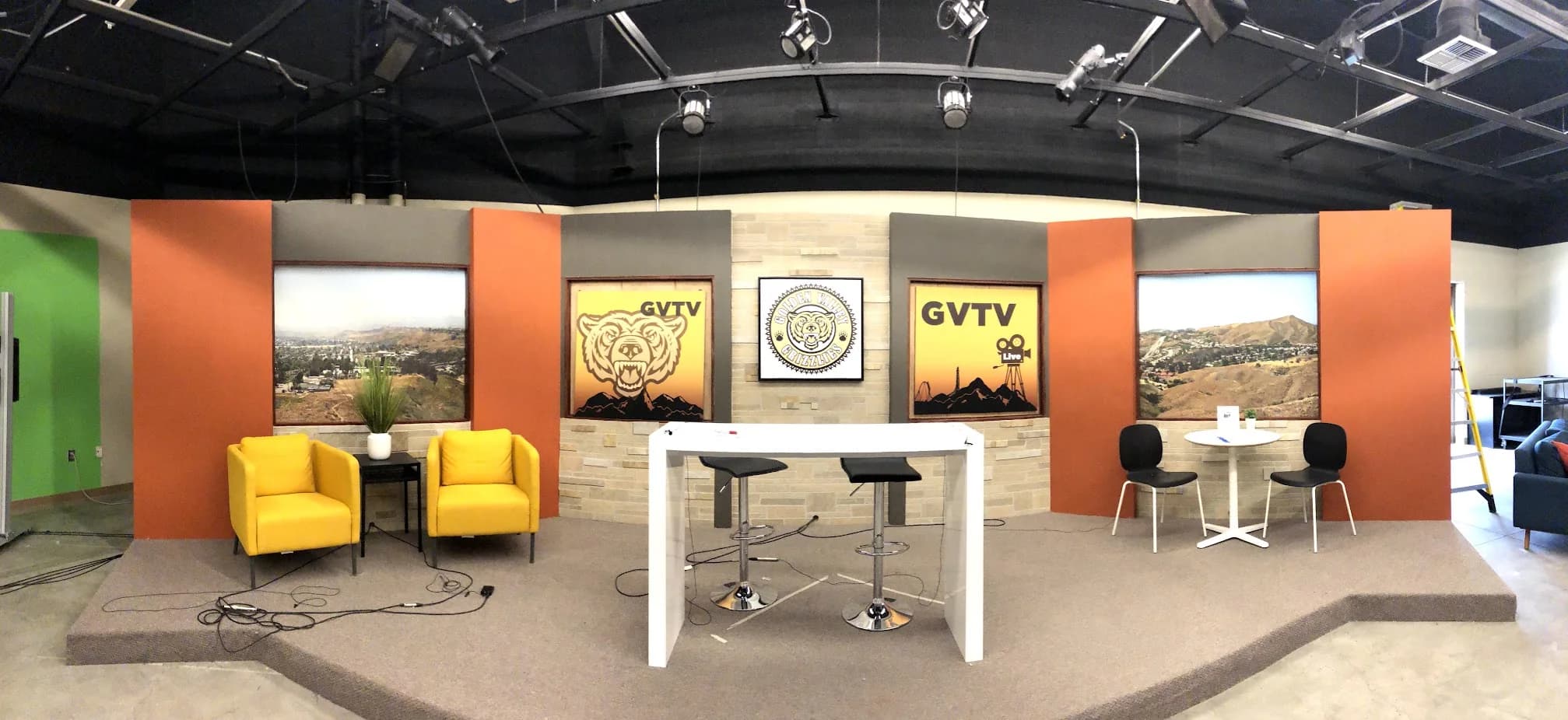 Finished Golden Valley TV studio with multiple presenter areas, displays, scenic panels, and overhead lighting