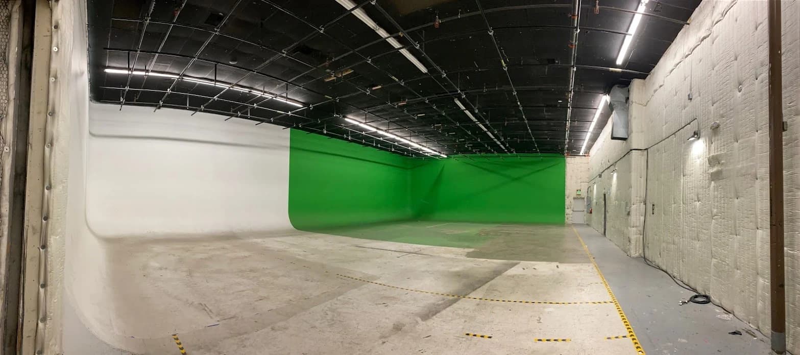 Burbank production stage with white and chroma-green cycs beneath the overhead grid