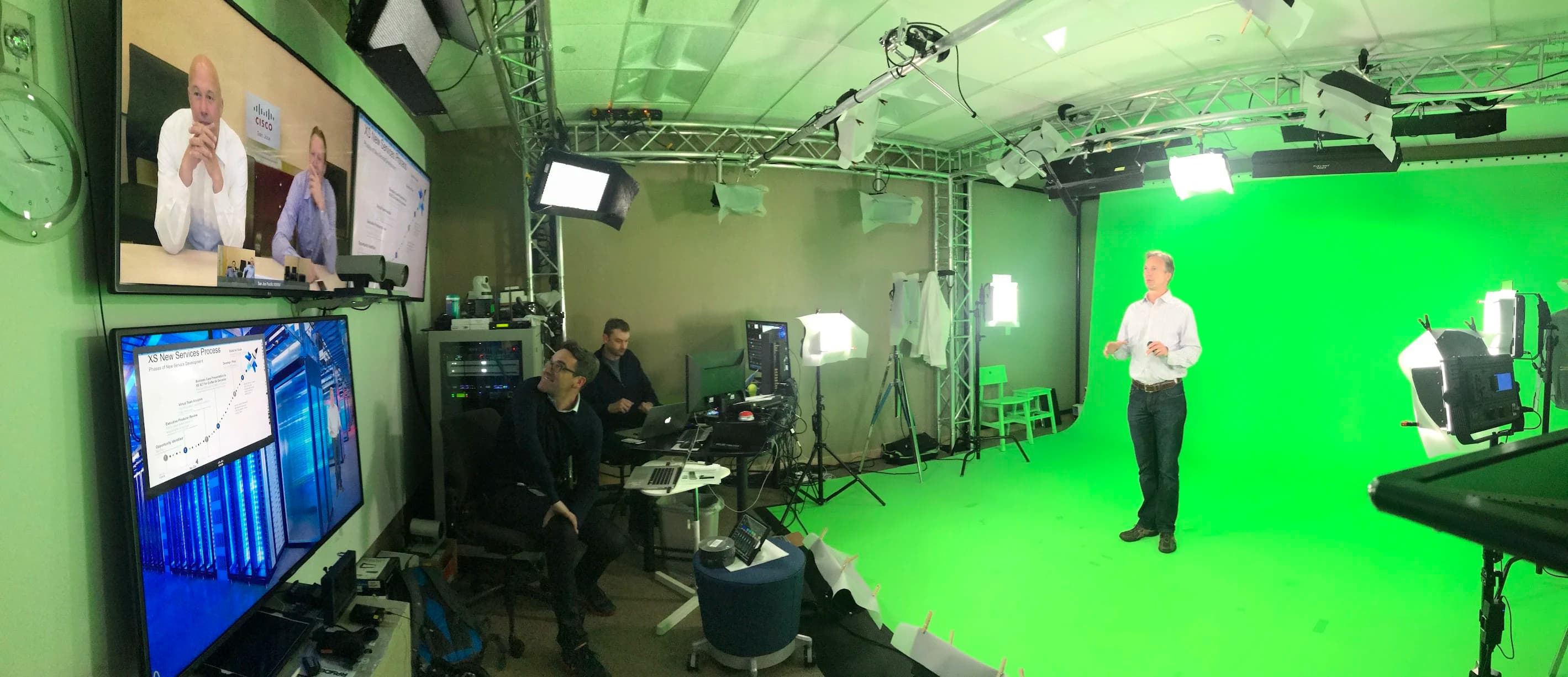 Cisco Geary Studio in operation with a presenter on the green screen and remote participants on the displays