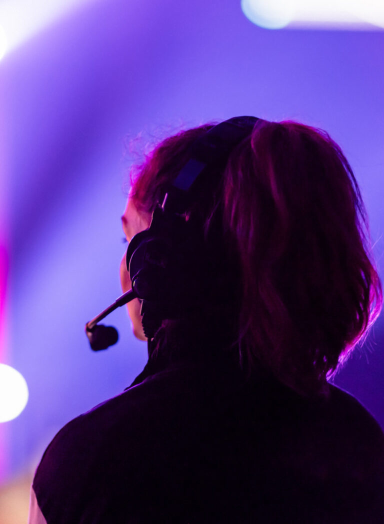 Female audio video technician overseeing event setup, showcasing AV staff augmentation services.